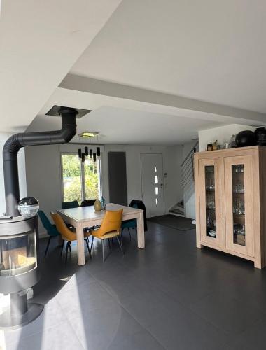 une cuisine avec une table, des chaises et une cuisinière dans l'établissement Villa Proche paris, à Servon