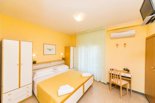 a hotel room with a bed and a desk at Hotel Rita in Riccione