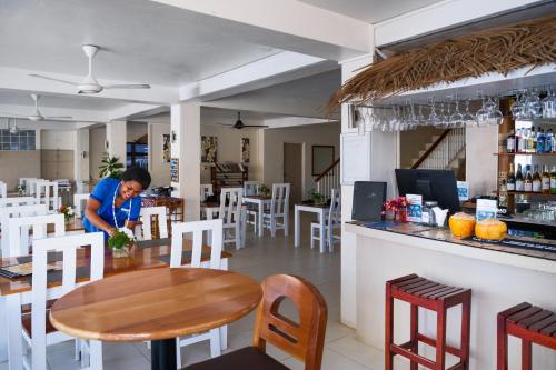 a person standing at a table in a restaurant at Aquarius On The Beach in Nadi