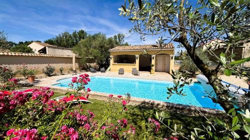 une villa avec une piscine dans un jardin dans l'établissement Maison de campagne mas Célestin, à Camaret-sur-Aigues