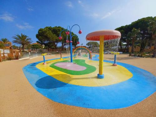 un parco giochi in un parco con una fontana d'acqua di Camping siblu - 8pers - 100m des plages a Canet-en-Roussillon