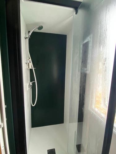 une douche avec une porte vitrée dans une salle de bain dans l'établissement Camping siblu - 8pers - 100m des plages, à Canet