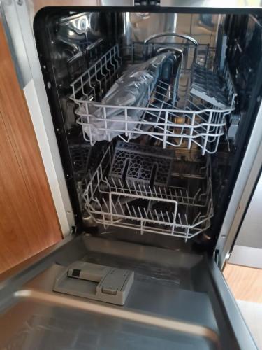 un lave-vaisselle vide avec de la vaisselle à l'intérieur dans l'établissement Camping siblu - 8pers - 100m des plages, à Canet