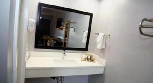 a white bathroom with a sink and a mirror at Grand Park Inn in Baldwin Park