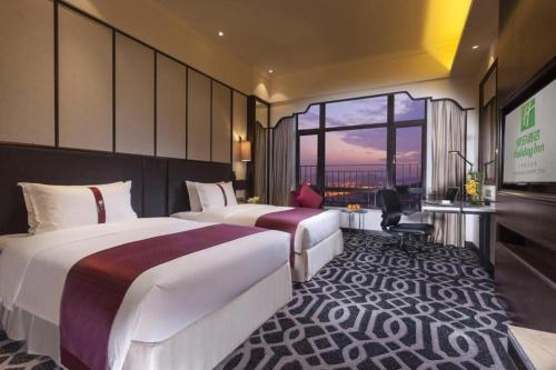 two beds in a hotel room with a view at Holiday Inn Guangzhou Airport Zone By IHG in Huadu