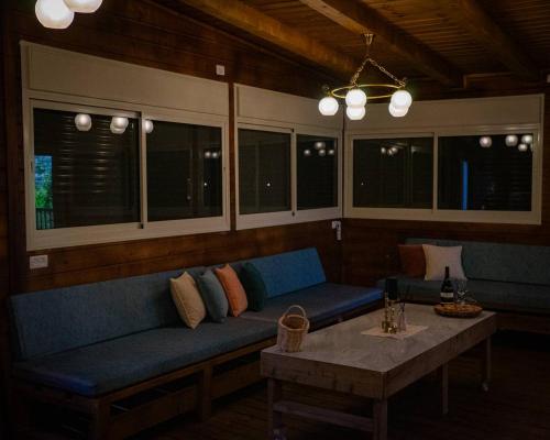 a living room with a blue couch and a table at Vida Bhermon The Golan Trail in Majdal Shams