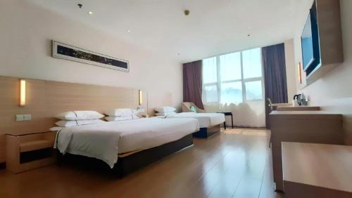 a hotel room with two beds and a sink at City Comfort Inn Jingzhou Ancient City Taiyue Road in Caoshi