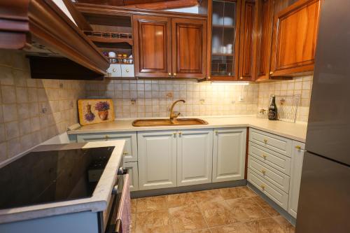 a kitchen with white cabinets and a sink at Aeolian Stone Villa in Koilás