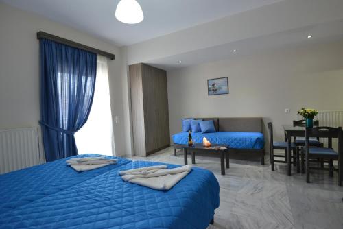a hotel room with two beds and a table at Vesperi Studios & Apartments in Rethymno Town