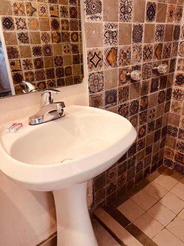 a bathroom with a white sink and a mirror at Eco-Hotel in Mazatlán