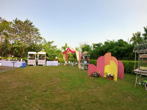 a park with tables and chairs in the grass at Novotel Imagicaa Khopoli in Khopoli
