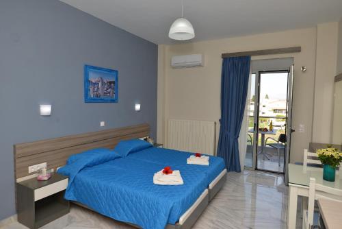 um quarto com uma cama azul com toalhas em Vesperi Studios & Apartments em Rethymno Town
