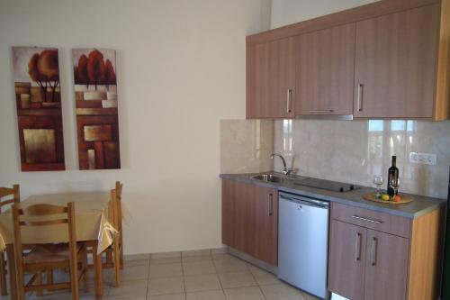 a kitchen with a sink and a table with a bottle of wine at Gramvoussa Bay in Kissamos