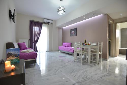 a living room with a table and a purple couch at Vesperi Studios & Apartments in Rethymno Town