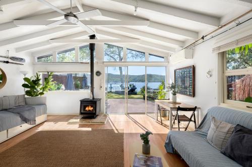 a living room with a couch and a fireplace at Island Paradise - Private Waterfront Retreat in Scotland Island