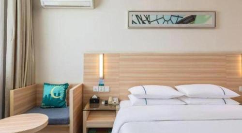 a hotel room with a bed and a table at City Comfort Inn Xiangyang Railway Station in Xiangyang
