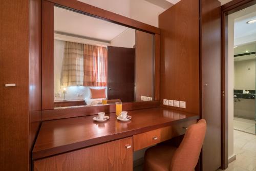 a bathroom with a vanity with a large mirror at Zante Park Resort & Spa BW Premier Collection in Laganas