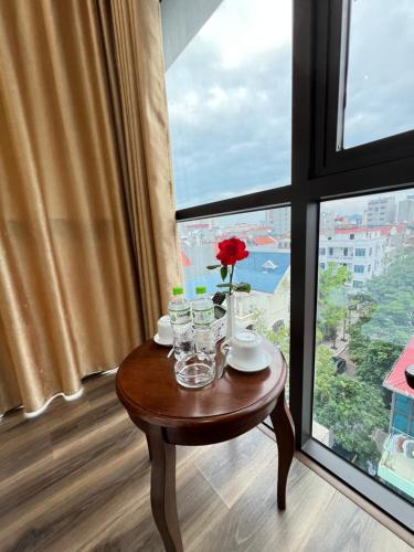 a table in front of a window with a flower on it at Sky Night Hotel in Bồ Sơn
