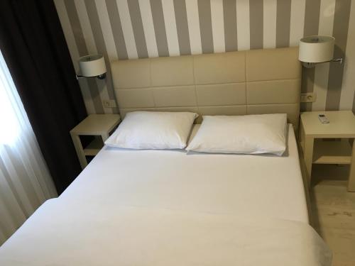 a bed with two white pillows in a room at Pansion Bencun in Međugorje