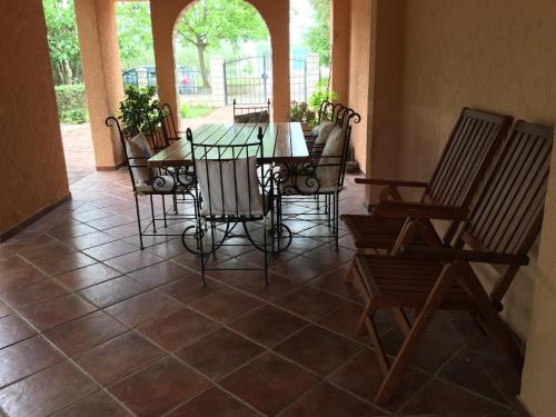 a patio with a table and chairs on a tiled floor at Pansion Bencun in Međugorje