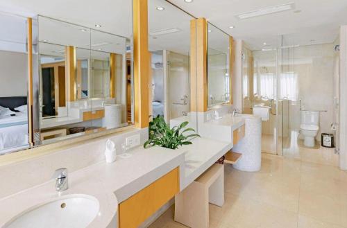 a large bathroom with two sinks and two mirrors at New Century Pujiang Hotel in Xiajizhai