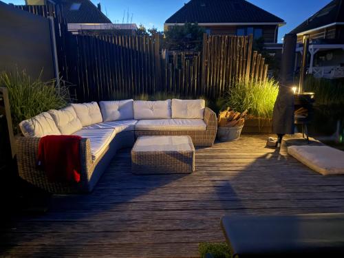 a white couch sitting on a wooden deck at Hart van Petten in Petten