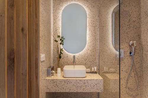 a bathroom with a shower with a sink and a mirror at Grand Hotel Du Golfe - Spa & Restaurant in Collioure