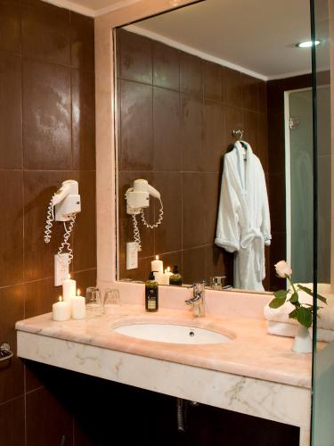 a bathroom with a sink and a mirror at Zante Park Resort & Spa BW Premier Collection in Laganas