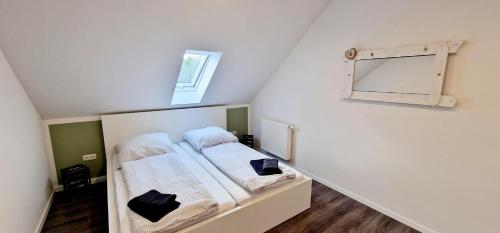 a small room with a bed and a mirror at Ferienhaus Strandallee 10a in Burhave