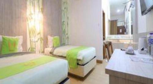 a hotel room with two beds and a sink at Hotel Huswah Airport in Jakarta