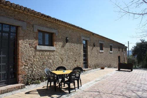 a table and chairs in front of a brick building at Azienda Agrituristica Le Puzelle in Santa Severina
