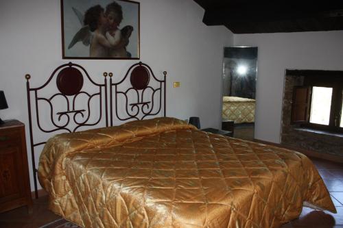 a bedroom with a bed with a gold bedspread at Azienda Agrituristica Le Puzelle in Santa Severina