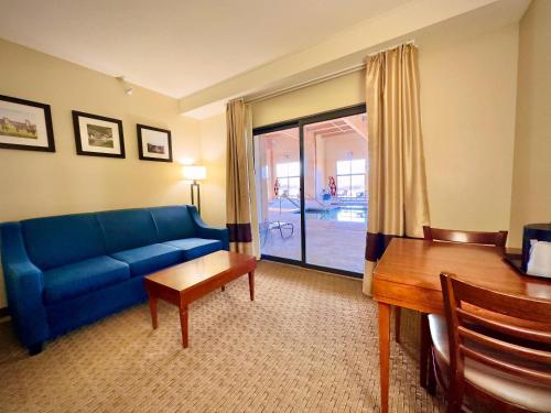 a living room with a blue couch and a table at Comfort Inn & Suites Black River Falls I-94 in Black River Falls