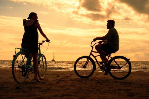 a man and a woman riding bikes on the beach at Aquarius On The Beach in Nadi