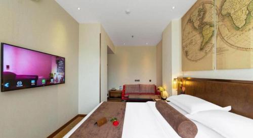 a bedroom with a large bed with a tv on the wall at James Joyce Coffetel Xi'an Lingtong The Terracotta Army Huaqingchi University Town Metro Station in Xi'an