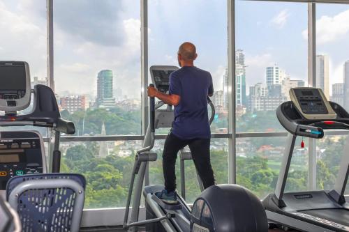 a man on a treadmill in a gym looking out the window at The Grandmark Dhaka in Dhaka