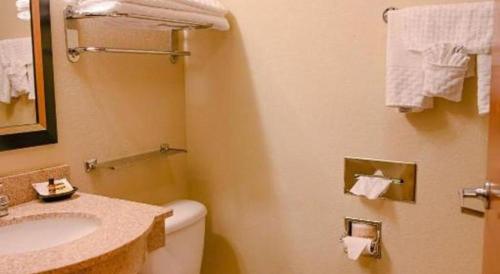 a bathroom with a toilet and a sink and towels at Best Western Plus Guymon Hotel and Suites in Guymon