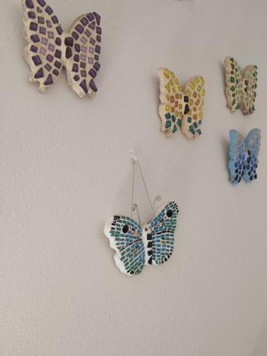 a group of butterflies hanging on a wall at Angelika Inn in Longá