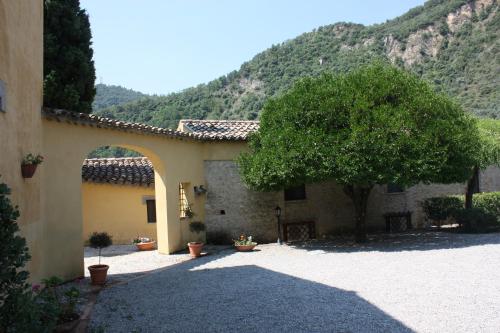 a building with a tree in the middle of a courtyard at Azienda Agrituristica Le Puzelle in Santa Severina