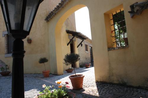 an archway in a building with potted plants and a street light at Azienda Agrituristica Le Puzelle in Santa Severina