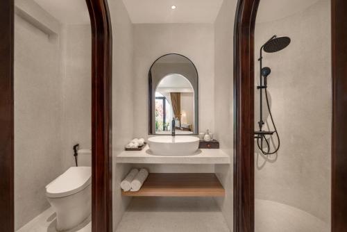 a bathroom with a sink and a toilet and a mirror at Saha Casa Boutique Hotel Da Nang in Da Nang