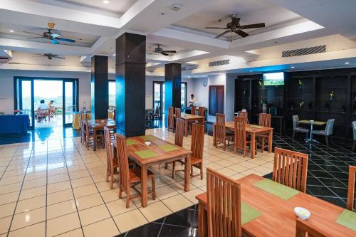 a dining room with wooden tables and chairs at New Kuta Hotel by LORIN in Uluwatu