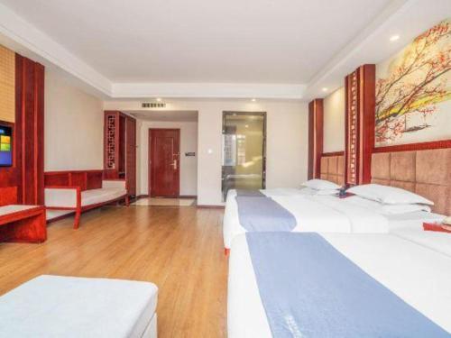 a bedroom with two beds and a living room at GreenTree Inn Kunming Baiyun Road Tongde Plaza Branch in Kunming