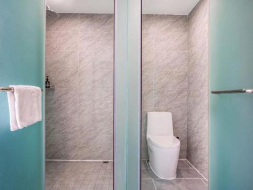 a bathroom with a toilet and a shower at GreenTree Inn Kunming Baiyun Road Tongde Plaza Branch in Kunming