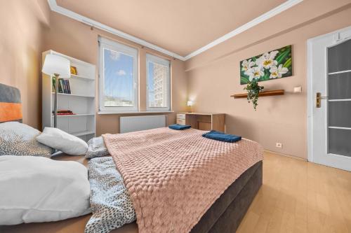 une chambre avec un grand lit et deux fenêtres dans l'établissement Big 4-room SPACIOUS apartment, à Bratislava