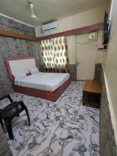 a bedroom with a bed and a carpeted floor at Hotel Shivtara in Nānded