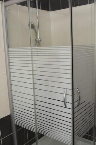 a shower with glass doors in a bathroom at B&B L'Angolo in Sannicola