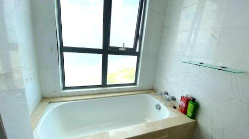 a bath tub in a bathroom with a window at Silverscape Seaview Residence Melaka in Melaka