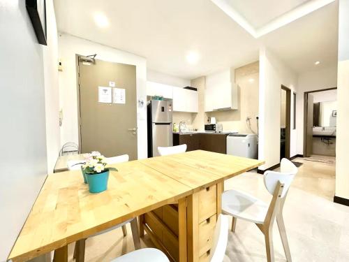 a kitchen with a wooden table and white chairs at Silverscape Seaview Residence Melaka in Melaka