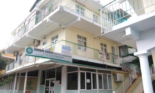 a building with a sign for a green cross hospital at Bano Tourist Residence - 650 meters from Grand Bay Beach in Grand Baie